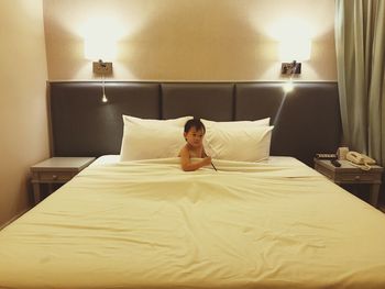 Boy sitting on bed at home