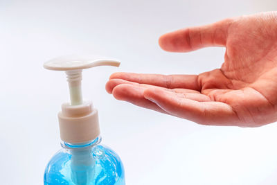 Close-up of person holding hands against white background