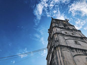 Low angle view of bell tower against blue sky