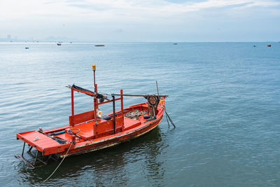 Boat moored in sea against sky