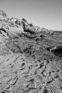 Rock formation on beach against clear sky