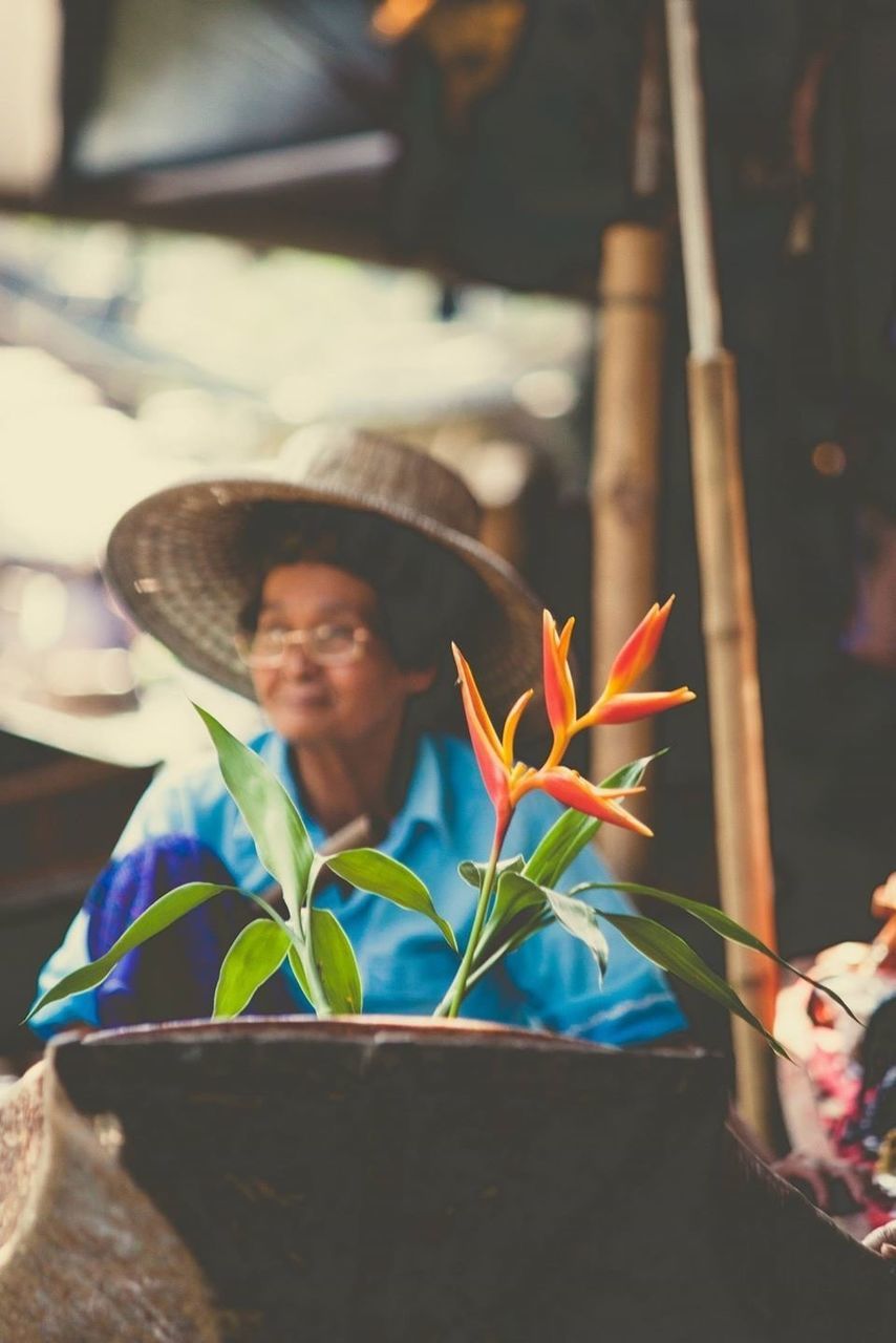 lifestyles, leisure activity, focus on foreground, casual clothing, person, front view, standing, holding, headshot, smiling, elementary age, childhood, waist up, portrait, looking at camera, park - man made space, young adult, selective focus