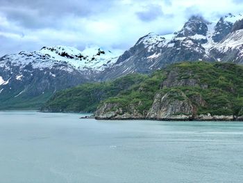 Scenic view of sea and mountains against cloudy sky