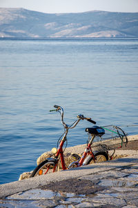 Bicycle on beach against mountain