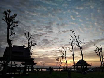 Silhouette trees on landscape against sky during sunset