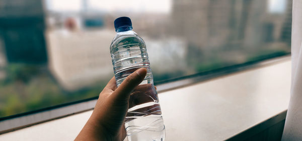 Cropped hand holding bottle