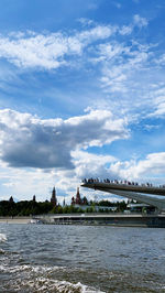 Bridge over river against cloudy sky