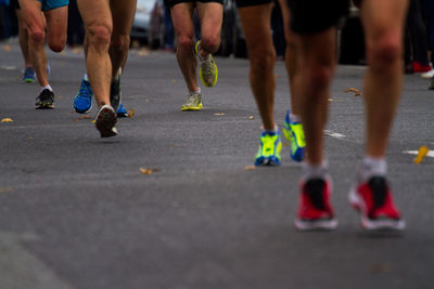 Low section of people running on street in marathon