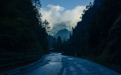 Road amidst trees against sky