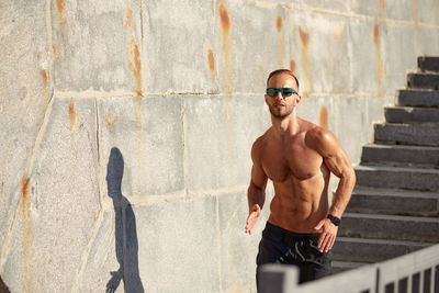 Side view of man standing against wall