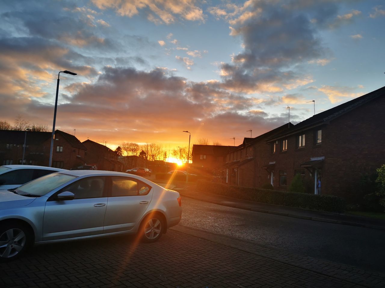 CARS ON ROAD AGAINST SKY DURING SUNSET