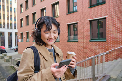 Young woman using mobile phone in city