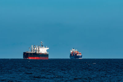 View of ship in sea against clear blue sky