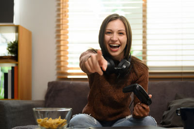 Young woman using mobile phone while sitting on table