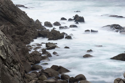 Rocks in sea against sky