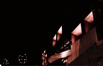 Low angle view of illuminated building against sky at night