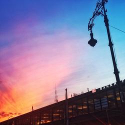 Low angle view of illuminated street light against sky at dusk