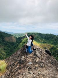 Man standing on rock in mountains against sky