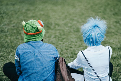 Rear view of people sitting on grass