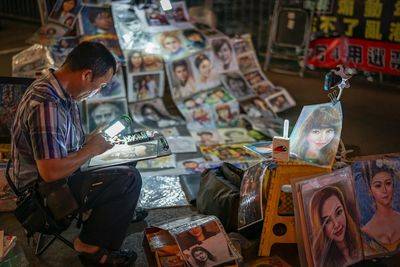 Portrait painter selling his paintings in flea market