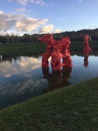 Reflection of man standing on lake against sky