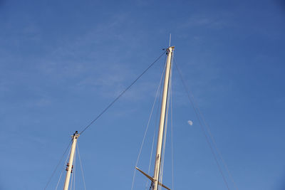 Low angle view of sailboat against blue sky