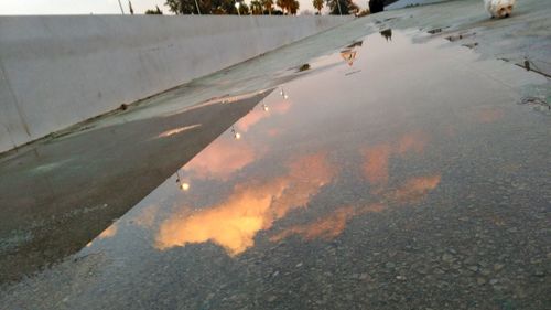 Reflection of sky in puddle on road