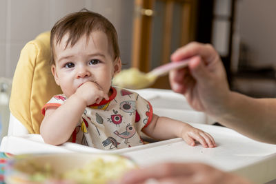 Girl child eating some baby food for lunch.