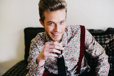 Portrait of young man having drink at home