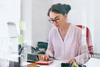 Attentive female bookkeeper check accounts bills. middle-aged woman social worker