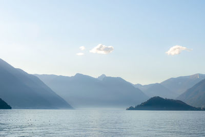 Scenic view of sea and mountains against sky