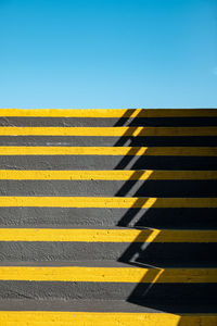 Low angle view of multi colored wall against clear blue sky