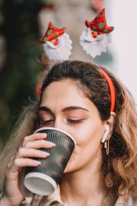 Portrait of young woman drinking coffee from a takeaway cup
