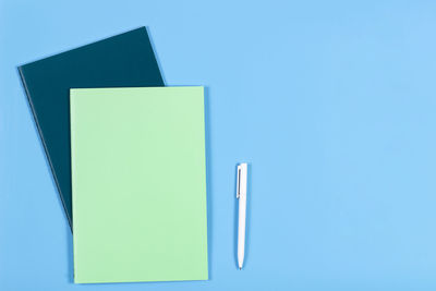 Close-up of books with pen on blue background