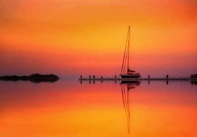 Silhouette of marina against orange sky