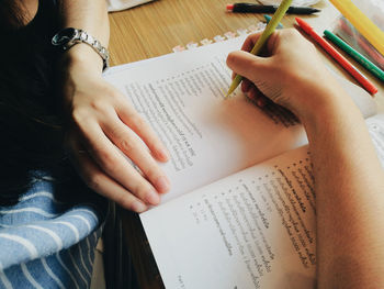 Midsection of man reading book on table