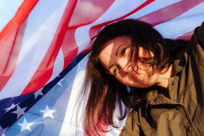 Closeup portrait of beautiful woman holding usa flag celebrating independance us day