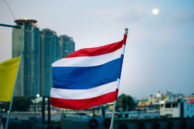 Thai flag waving in city against sky 