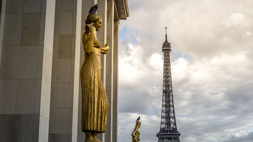 Low angle view of statues with eiffel tower in background