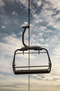 Low angle view of ski lift against sky during sunset