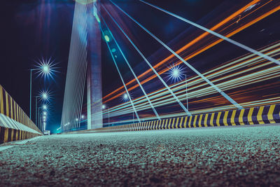 Light trails on road in city against sky at night