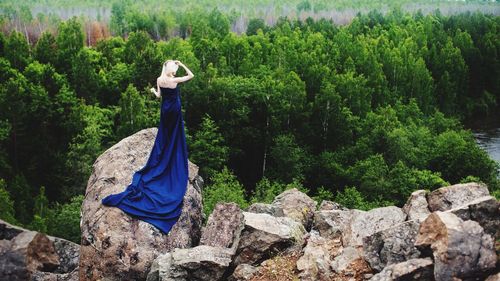 Woman standing on rock in forest