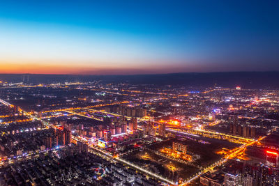 High angle view of illuminated buildings against sky at night