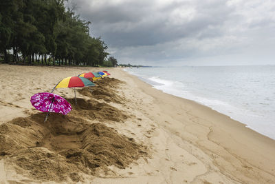 Sand spa hole and parasols ready to serve tourists at thap sakae beach prachuap khiri khan, thailand