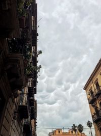 Low angle view of buildings against cloudy sky