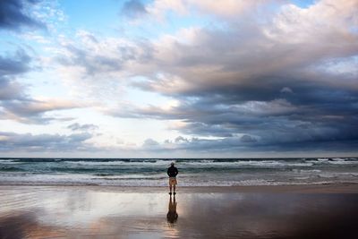 Scenic view of beach against cloudy sky