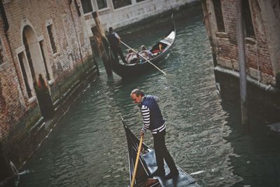 Man standing on boat in canal