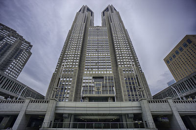 Low angle view of tokyo metropolitan government building in city against sky