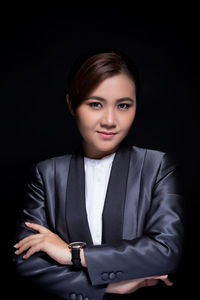 Portrait of a beautiful young woman over black background