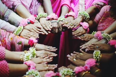 High angle view of women wearing flowers while standing in circle